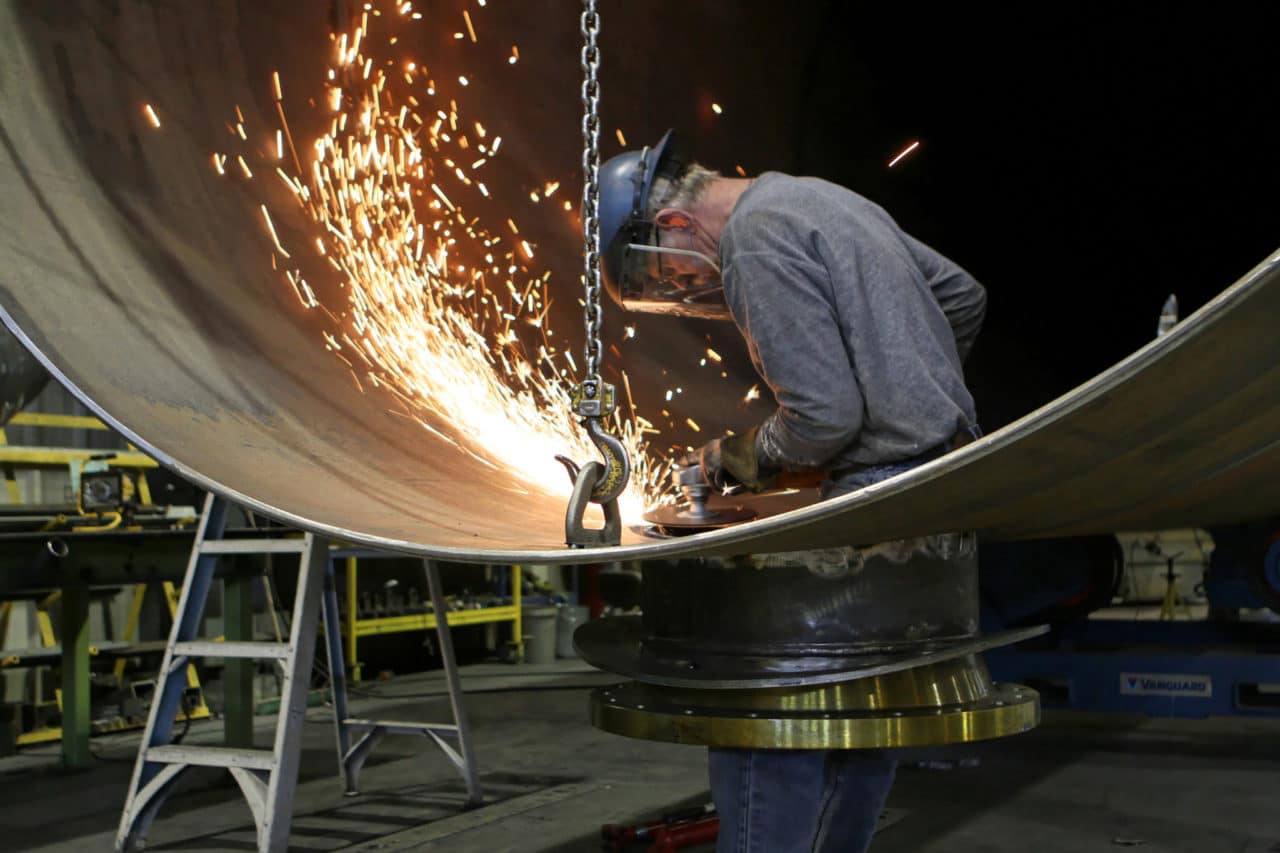 Photo of a person wearing protective gear while metal working with power tools