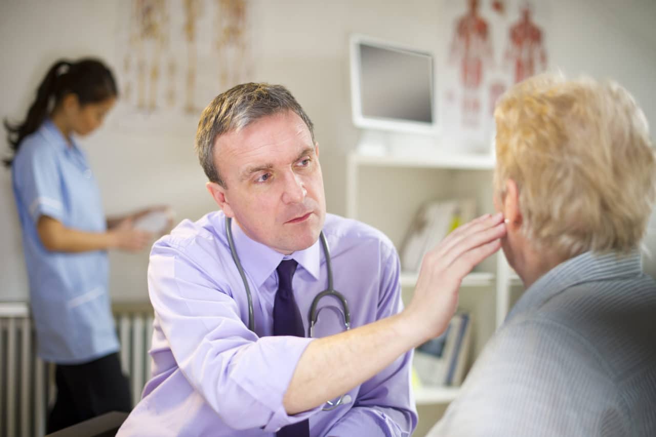 Photo of a provider touching a patient's ear