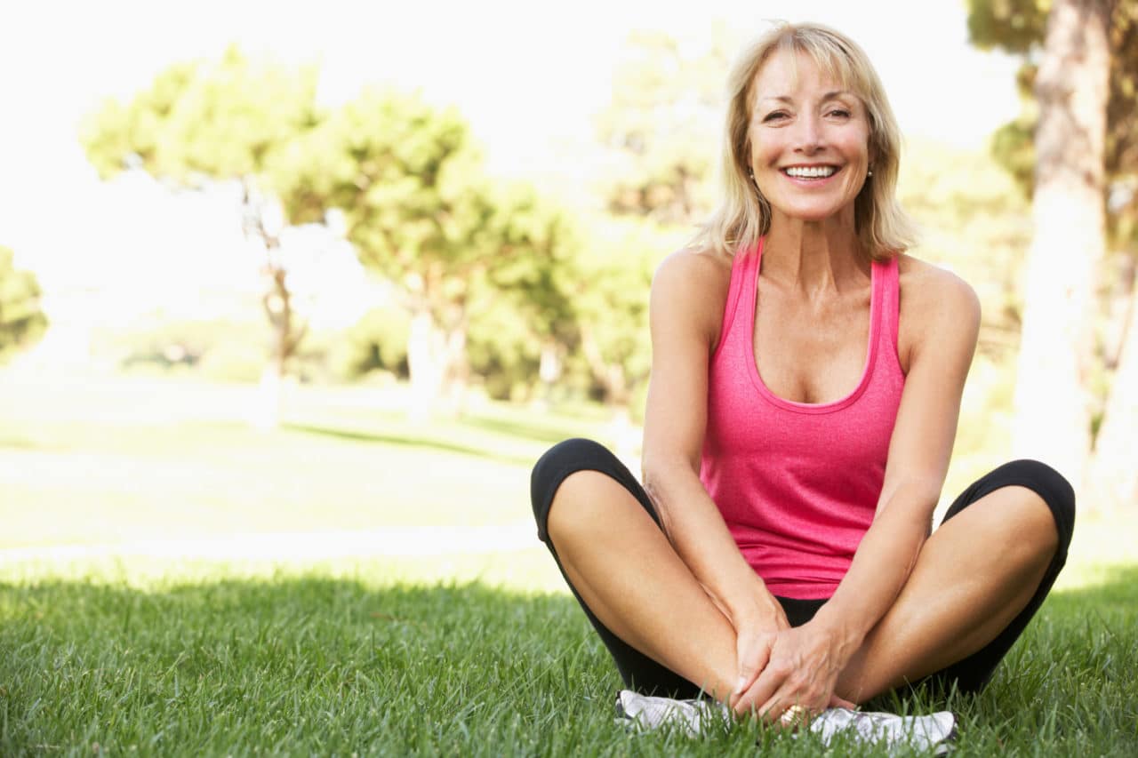 Photo of a woman smiling as she sits cross-legged