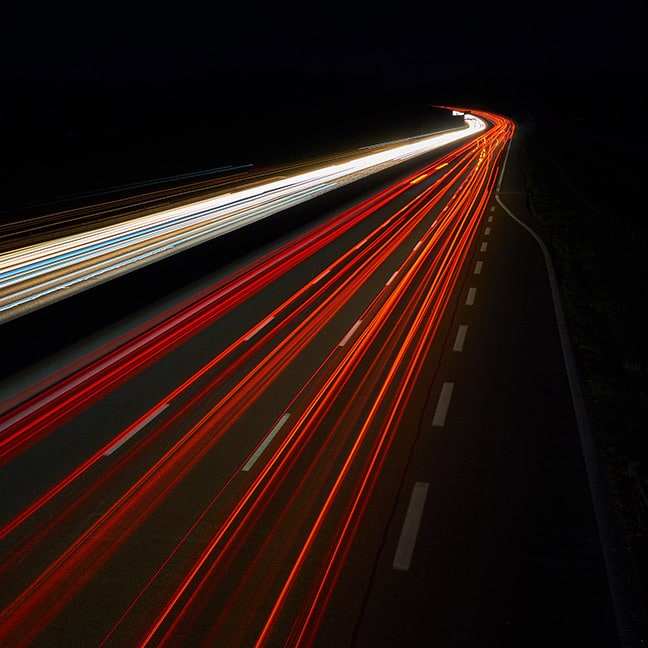 A long-exposure photo of car lights streaming through the night