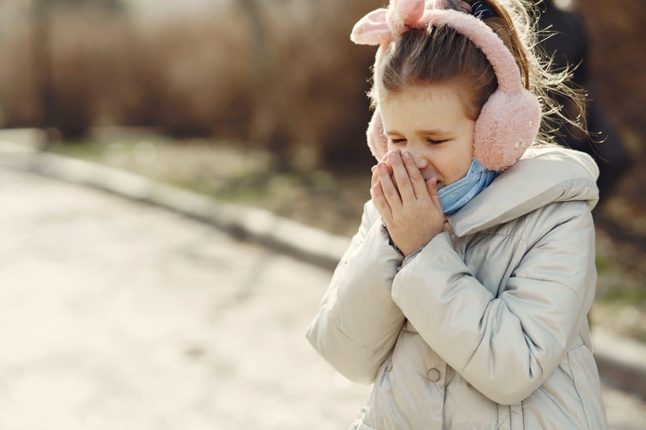 Little girl covering her nose.