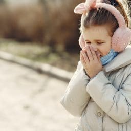 Little girl covering her nose.