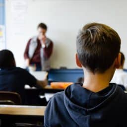 Children paying attention to a teacher in a classroom.