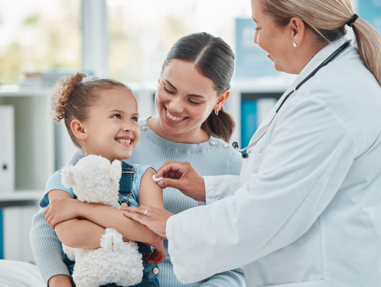 Shot of a doctor using a cotton ball on a little girl's arm while administering an injection in a clinic