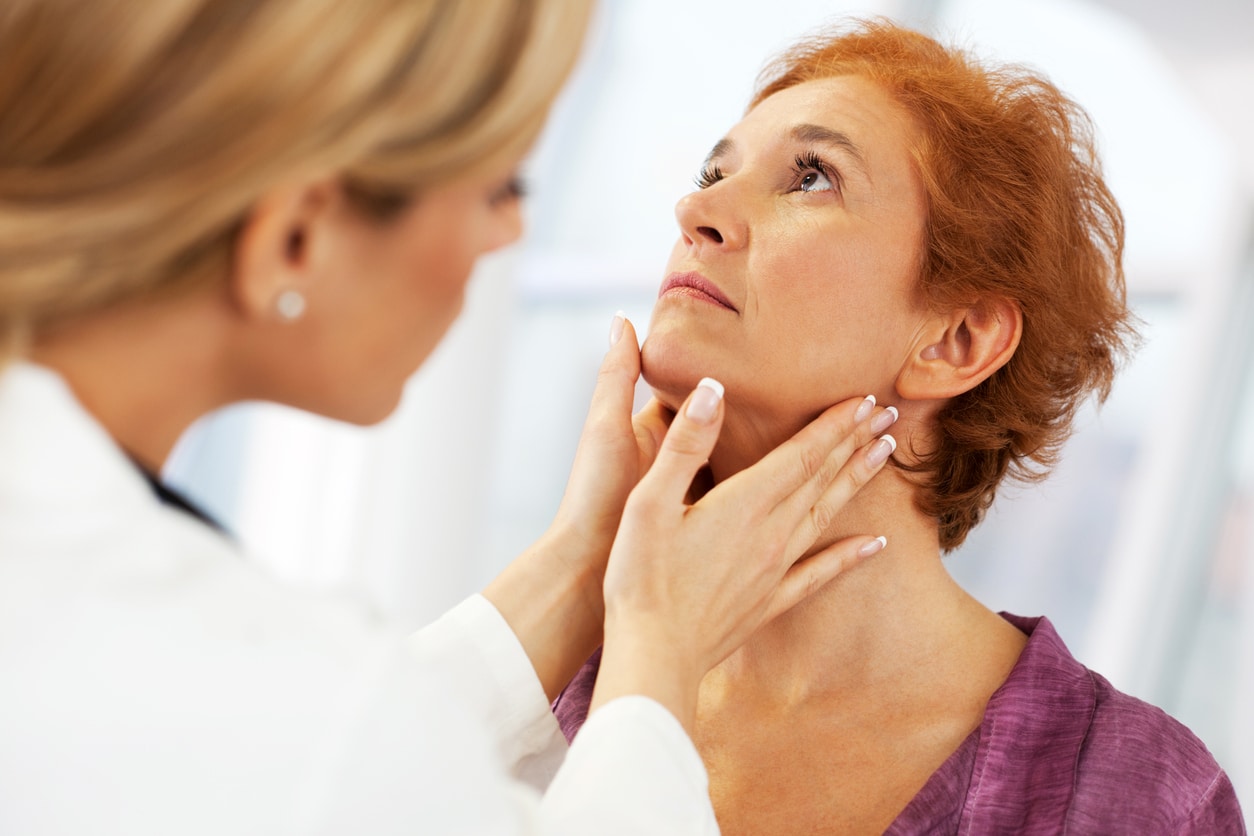 Doctor examines woman's neck