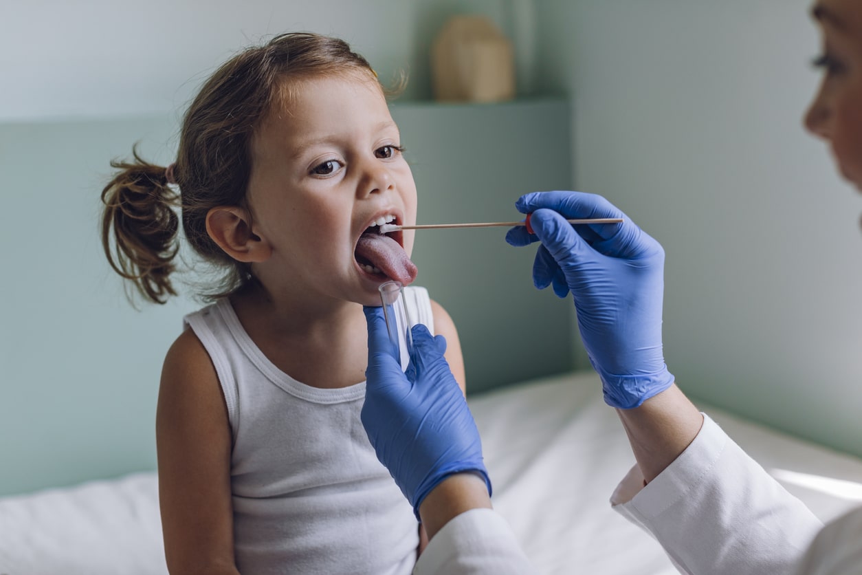 Young girl getting a throat swab.