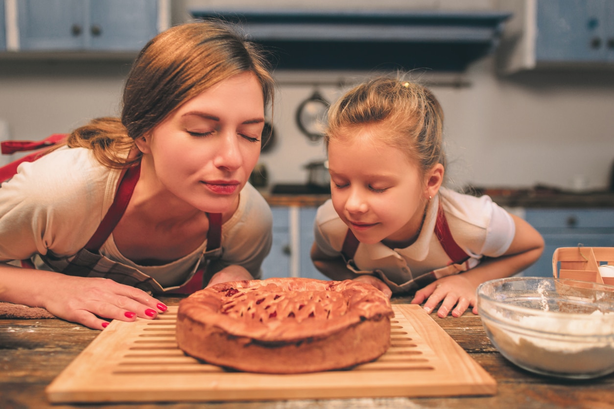 Mom and daughter smelling a freshly baked pie.