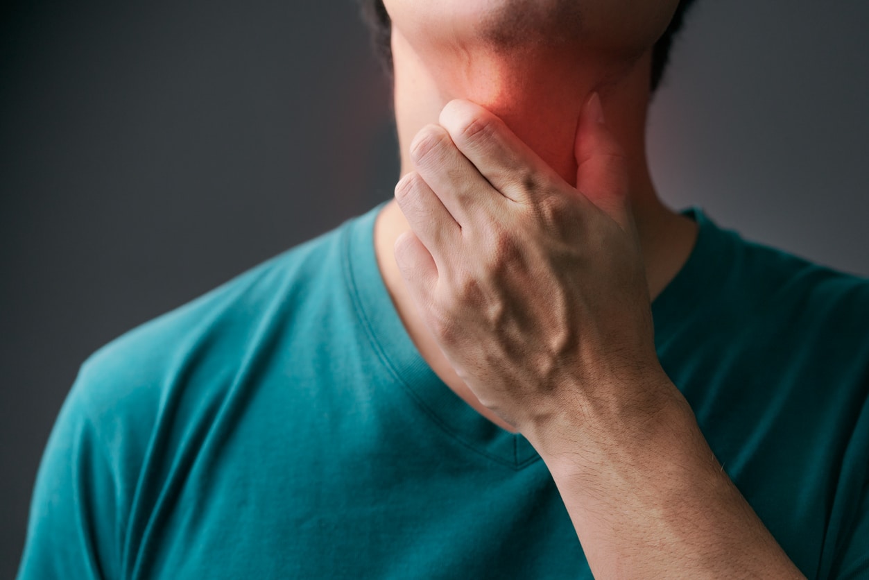 Man holding inflamed throat.