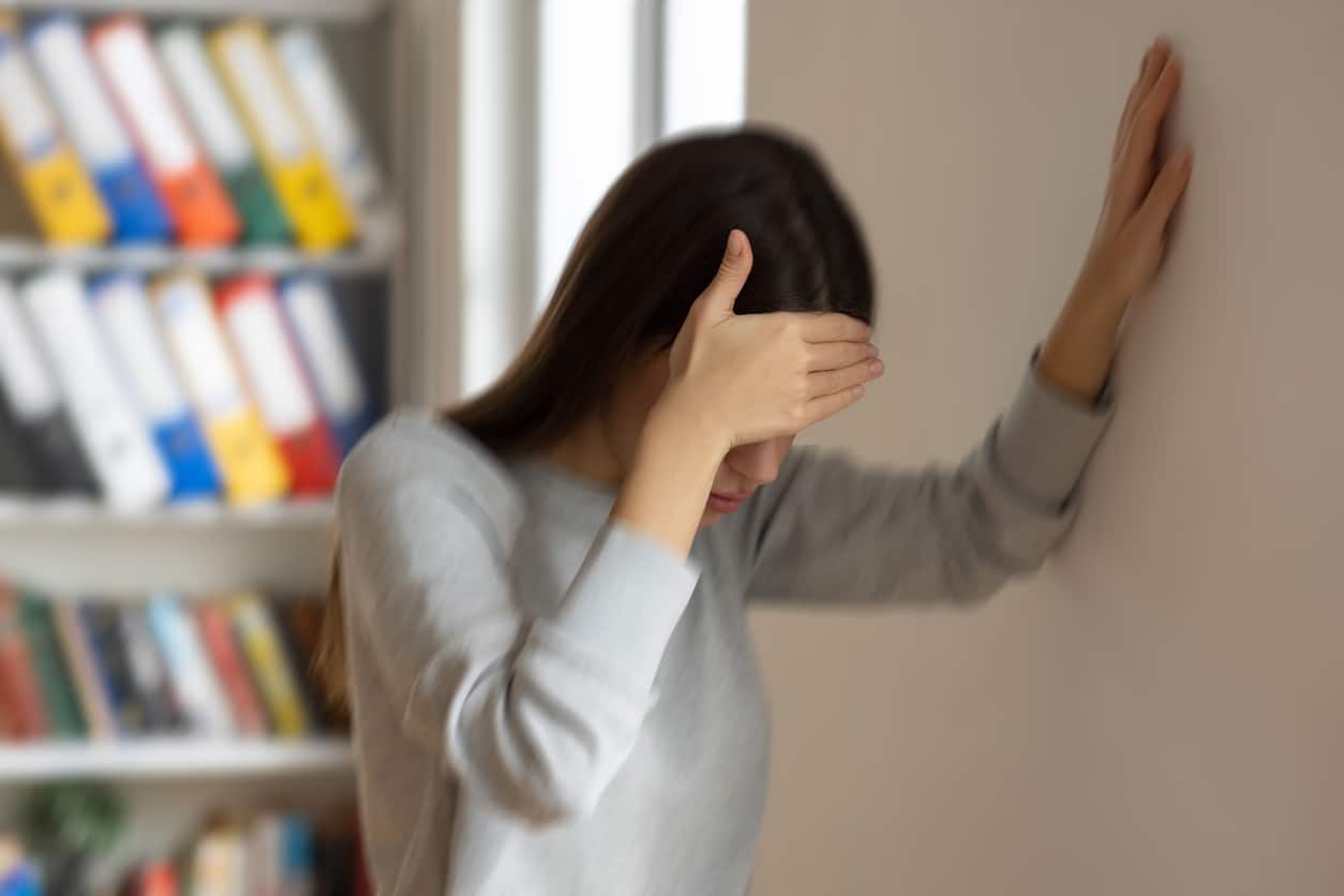 Woman holds wall with balance issue
