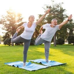 Two people with great balance doing yoga in the park.