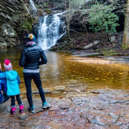 Mother, father, and daughter enjoying the beautiful Lower Cascade waterfall in Hanging Rock State Park in central North Carolina, Southern USA